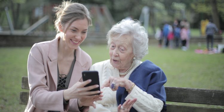 cheerful-senior-mother-and-adult-daughter-using-smartphone