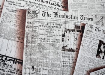 Front pages of newspapers displayed across a table