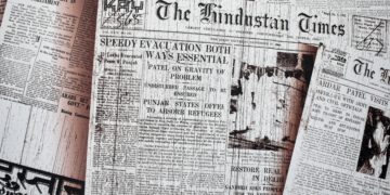 Front pages of newspapers displayed across a table