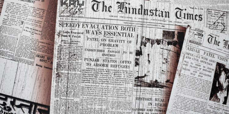 Front pages of newspapers displayed across a table