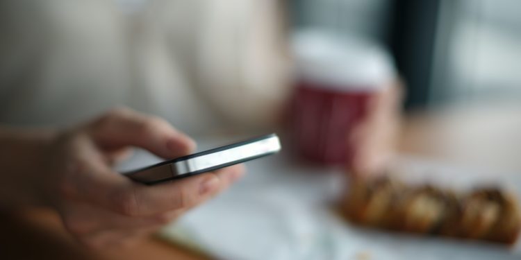 Person on phone at breakfast