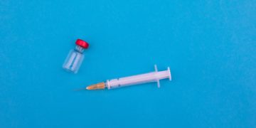 Empty vaccine vial and needle