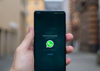 An android phone being held up in front at eye level. The whatsapp application is being opened