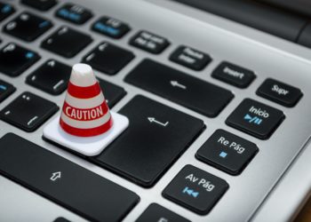 Small caution cone placed over the 'enter' key on a macbook keyboard.