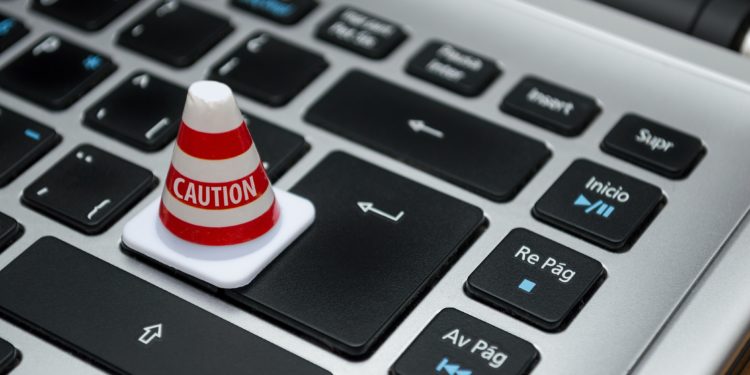 Small caution cone placed over the 'enter' key on a macbook keyboard.