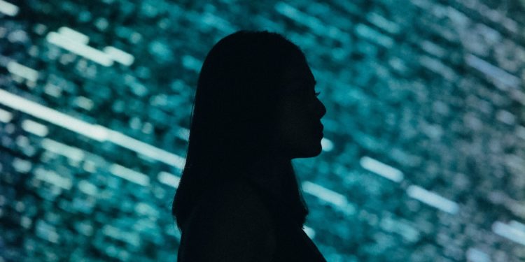 Female silhouette in front of code