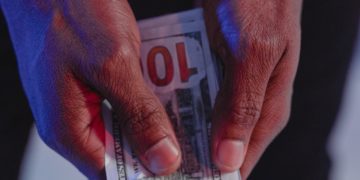 Handcuffed man holding money