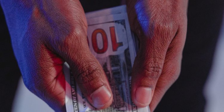 Handcuffed man holding money