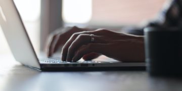 Close up of someone typing on a computer