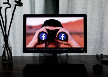 Computer desktop displaying man with binoculars that have the FB logo in the lenses