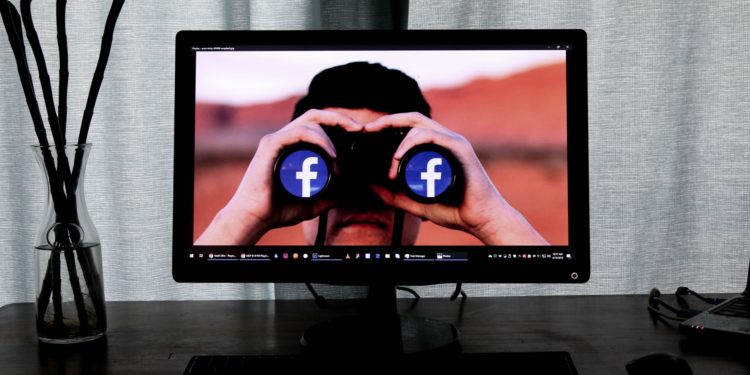 Computer desktop displaying man with binoculars that have the FB logo in the lenses
