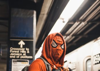 spiderman on the underground in a red hoodie