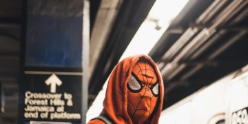 spiderman on the underground in a red hoodie