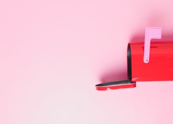 Pink mail box on a pink background with open letterbox