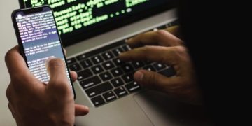 hacker using phone and computer
