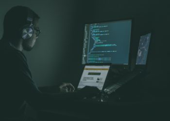 man coding on multiple screens