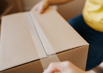 person taping parcel
