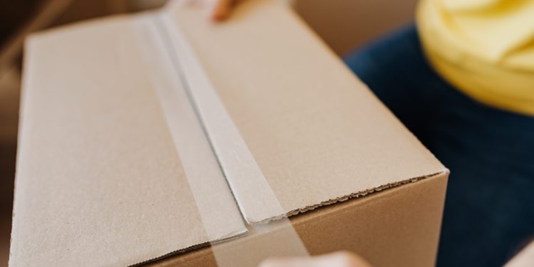person taping parcel