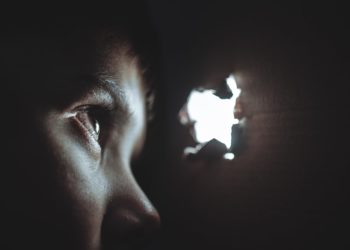 person peeping through hole