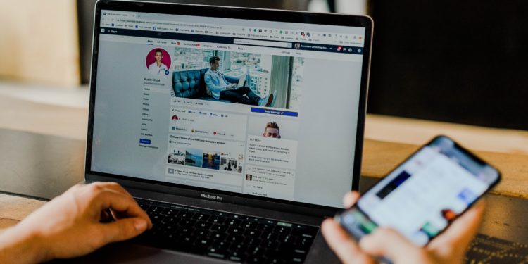 Open laptop and phone using Facebook