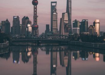 City skyscrapers at sunset, water reflection