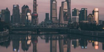 City skyscrapers at sunset, water reflection