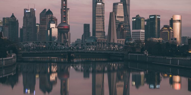 City skyscrapers at sunset, water reflection