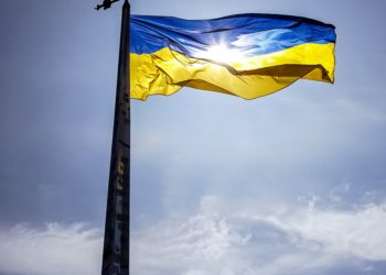 Ukraine Flag, blue sky. Yellow and blue flag on pole.