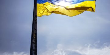 Ukraine Flag, blue sky. Yellow and blue flag on pole.