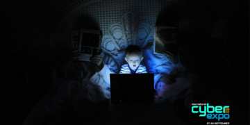 child on laptop in dark room. International Cyber Expo logo in corner.
