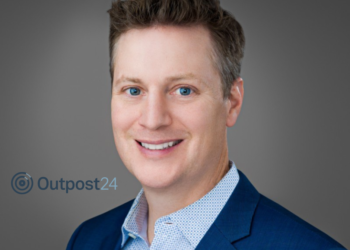 man in blue suit next to logo that reads 'outpost24'