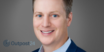 man in blue suit next to logo that reads 'outpost24'