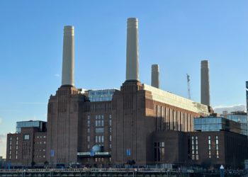Dimly Lit Battersea Power Station, blue sky.