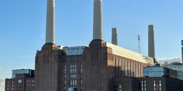 Dimly Lit Battersea Power Station, blue sky.