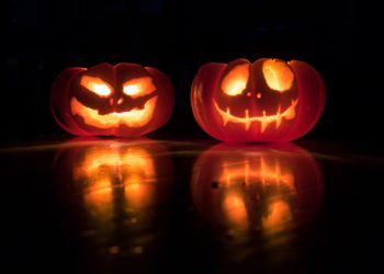 Halloween Pumpkins, dark room, lit carved faces.