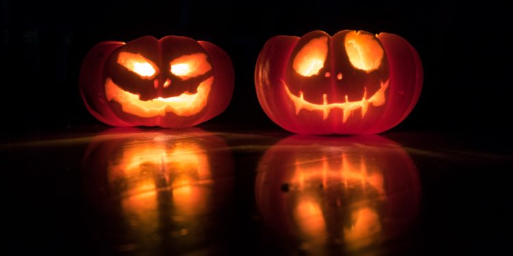 Halloween Pumpkins, dark room, lit carved faces.